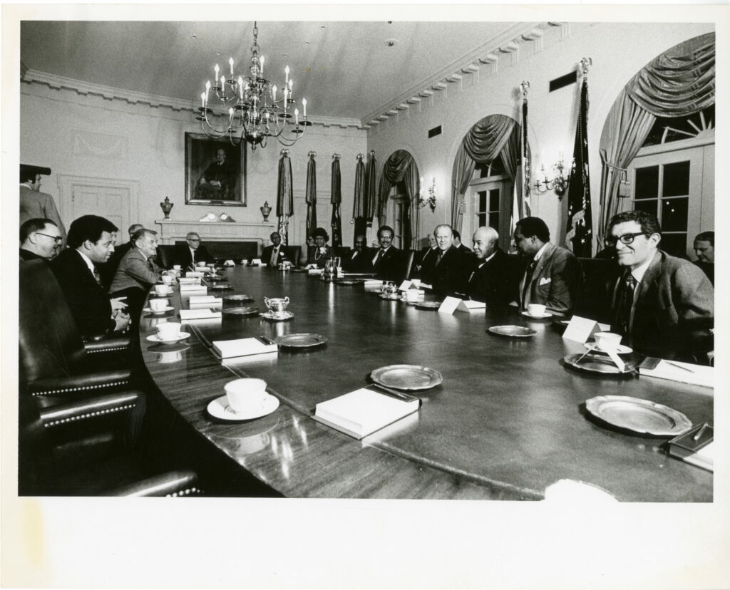 Msgr. Higgins with Gerald Ford, Henry Kissinger, and others in the meeting room of the White House, 1975. American Catholic History Archives/The Catholic University of America (ACHR-CUA) 