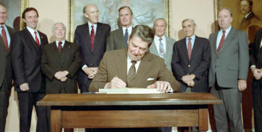 C37895-16, President Reagan in the Roosevelt Room signing S. 1200 Immigration Reform and Control Act of 1986 with Dan Lungren, Strom Thurmond,George Bush, Romano Mazzoli and Alan Simpson. 11/06/1986. Credit: National Archives